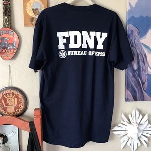 FDNY DEADSTOCK VINTAGE 90s SOUVENIR TSHIRT IN NAVY WITH FDNY BADGE ON CHEST.